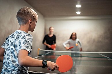 Kinder spielen zusammen Tischtennis im Family Home Alpenhof in Südtirol.