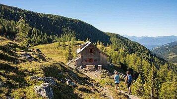 Zwei Erwachsene wandern durch die Kärntner Berge.