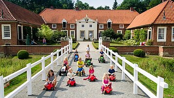 Kinder spielen mit Bobby Cars im Familienhotel Gut Landegge im Emsland.