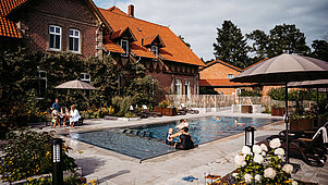 Familien am und im beheizten Außenpool im Bauerngarten im Landhaus Averbeck in der Lüneburger Heide..