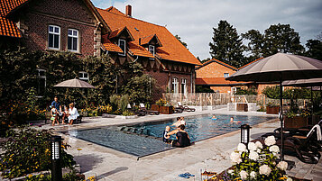 Familien am und im beheizten Außenpool im Bauerngarten im Landhaus Averbeck in der Lüneburger Heide..