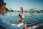 Vater und Sohn planschen im Natur-Badesee im Familien Resort Petschnighof