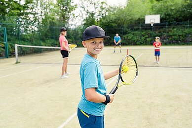 Familie auf dem Tennisplatz im Familienhotel Allgäuer Berghof.