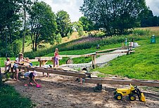 Wasserspielplatz mit großem Sandkasten und Spielzeugbaggern im Familienhotel Mein Krug im Fichtelgebirge.