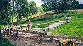 Wasserspielplatz mit großem Sandkasten und Spielzeugbaggern im Familienhotel Mein Krug im Fichtelgebirge.