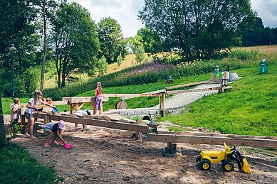 Wasserspielplatz mit großem Sandkasten und Spielzeugbaggern im Familienhotel Mein Krug im Fichtelgebirge.