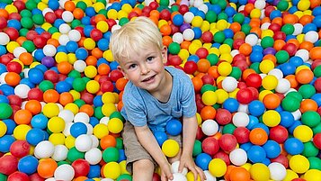 Kleiner Junge hat viel Freude im Bällebad des Familienhotels Engel im Schwarzwald.