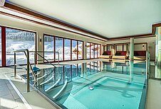 Panorama Hallenbad des Familienhotels Oberkarteis mit verschneiter Landschaft draußen.