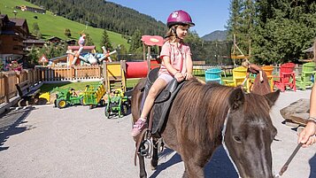 Kinder haqben viel freude beim Ponyreiten im Familienhotel Galtenberg in Tirol.