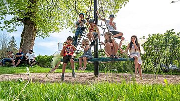 Kinder auf dem Outdoor-Kinderspielplatz im Familienhotel Mein Krug im Fichtelgebirge.