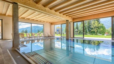 Lichtdurchfluteter Indoorpool mit traumhaftem Bergblick im Familienhotel Ramsi in Kärnten