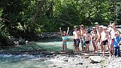 Einige Kinder bauen am kleinen Bach einen Staudamm am Wellness- und Familienhotel Egger im Salzburger Land.