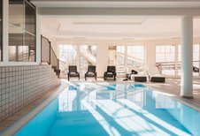 Schwimmbecken mit Liegen im Familienhotel Adler Familien- & Wohlfühlhotel in Tirol.