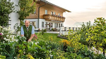 Ein Mann in seinem Garten vor seinem Haus in der Region Altenmarkt 