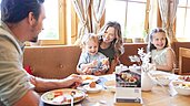 Eine junge Familie genießt das gemeinsame Frühstück im Familienhotel Das Hopfgarten in Tirol.