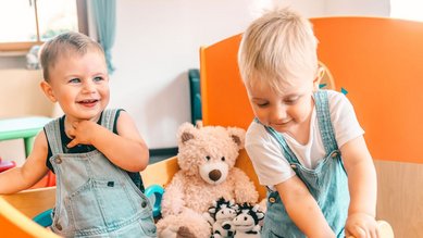 Kleinkinder spielen lachend im Wichtelclub des Familienhotel Friedrichshof.