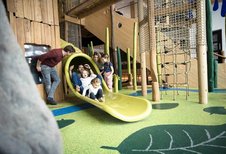 Vater rutscht mit seinen beiden Kindern die Röhrenrutsche im Familienhotel Allgäuer Berghof hinunter.