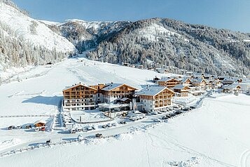 Luftaufnahme im Winter des Familienhotels Almfamilyhotel Scherer. 