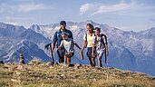 Eine Familien die in den Bergen Wandern geht.