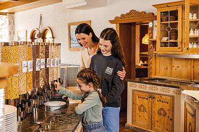 Familie bedient sich am reichhaltigen Frühstücksbuffet des Familienhotels Alpenhotel Kindl in Tirol.