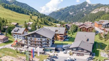 Sommer Luftaufnahme vom Hotelgelände Familienhotel Gorfion mit der umliegenden Landschaft in Lichtenstein.