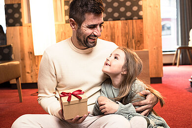 Ein Papa freut sich über ein Geschenk von seiner Tochter.