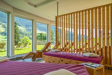 Ruhebereich mit Liegen und Panoramafenstern im Wellnessabteil des Familienhotels Kirchheimerhof in Kärnten.