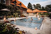 Familien planschen im Außenpool des Familienhotels Landhaus Averbeck in der Lüneburger Heide.