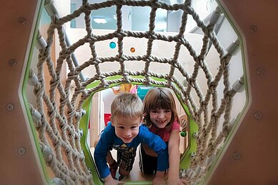 Zwei Kinder im Kletternetz des Happy-Clubs im Kinderhotel Stefan in Tirol.