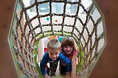 Zwei Kinder im Kletternetz des Happy-Clubs im Kinderhotel Stefan in Tirol.