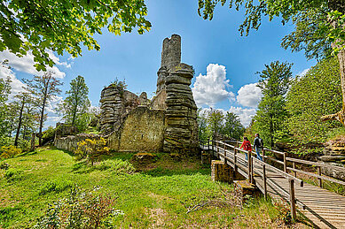 Wandern im Fichtelgebirge durch den Wald an alten Ruinen vorbei.