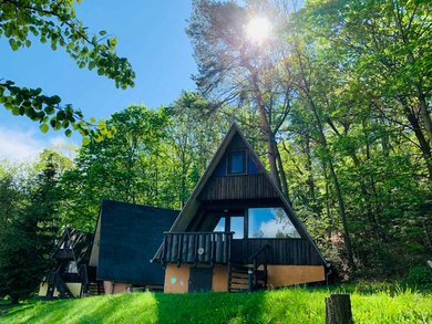 Großer Pool im Freien im Family Club Harz mit Sichtschutz aus Holz und zwei Treppen zum Einstieg.