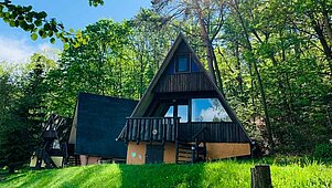 Großer Pool im Freien im Family Club Harz mit Sichtschutz aus Holz und zwei Treppen zum Einstieg.