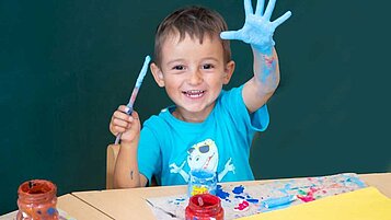 Junge beim Malen in der liebevollen Kinderbetreuung des Familienhotels Der Ponyhof in der Steiermark.