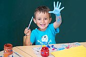 Junge beim Malen in der liebevollen Kinderbetreuung des Familienhotels Der Ponyhof in der Steiermark.