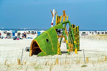 Bunter Kinderspielplatz in Form eines Fisches am familienfreundlichen Strand an der Nordsee