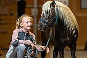 Das Mädchen freut sich das Pony im Elldus Resort Im Erzgebirge auszuführen.