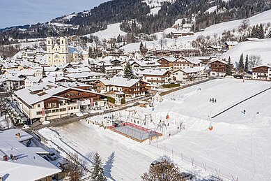 Luftaufnahme im Winter vom Familienhotel das Hopfgarten mit Ausblick auf die Landschaft.