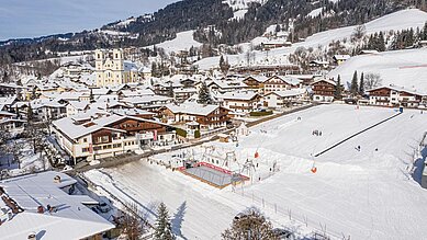 Luftaufnahme im Winter vom Familienhotel das Hopfgarten mit Ausblick auf die Landschaft.