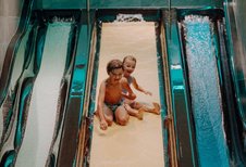 Zwei Kinder haben fröhlichen Rutschenspaß im Familienhotel Oberkarteis und genießen das Wasserabenteuer.
