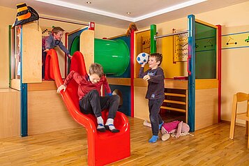 Spielende Kinder im Spielbereich im Familienhotel Sonne Bezau Vorarlberg.