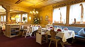 Gemütliches Restaurant mit Tageslicht und Babyhochstühlen im Familienhotel Bavaria im Allgäu.