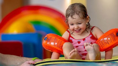Wasserspaß im Familienurlaub im Familienhotel Mein Krug. Ein Mädchen im Indoorpool beim spielen im Wasser.