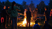 Familie am gemütlichen Lagerfeuer mit Stockbrot grillen im Bernsteinreiter Schlossresort