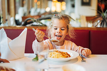 Mädchen isst Spagetti im Restaurant des Familienhotels Kirchheimerhof in Kärnten.