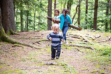 Im Familienhotel der Ponyhof Steiermark spielen Kleinkinder im Wald