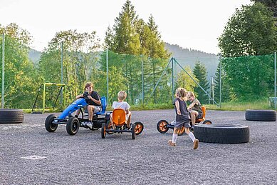 Kinder fahren Go-Karts auf dem Hotelgelände des Familienhotels Alpengasthof Hochegger in Kärnten