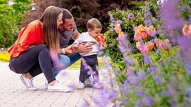 Familie mit Kind im Garten im Familienhotel Kolping Hotel Spa & Family Resort in Ungarn.