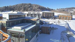 Das Familienhotel Schreinerhof im Bayerischen Wald von außen im Winter mit einer großen Außenanlage und Outdoor-Spielplatz für Kinder.