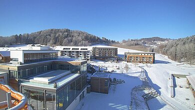 Das Familienhotel Schreinerhof im Bayerischen Wald von außen im Winter mit einer großen Außenanlage und Outdoor-Spielplatz für Kinder.